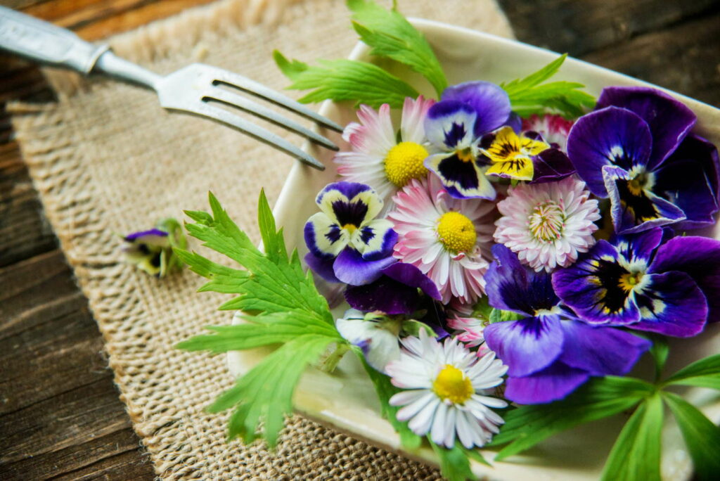 Eetbare bloemen op een bord met vork