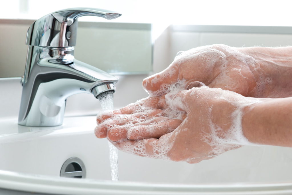 Handen worden gewassen onder een waterstraal