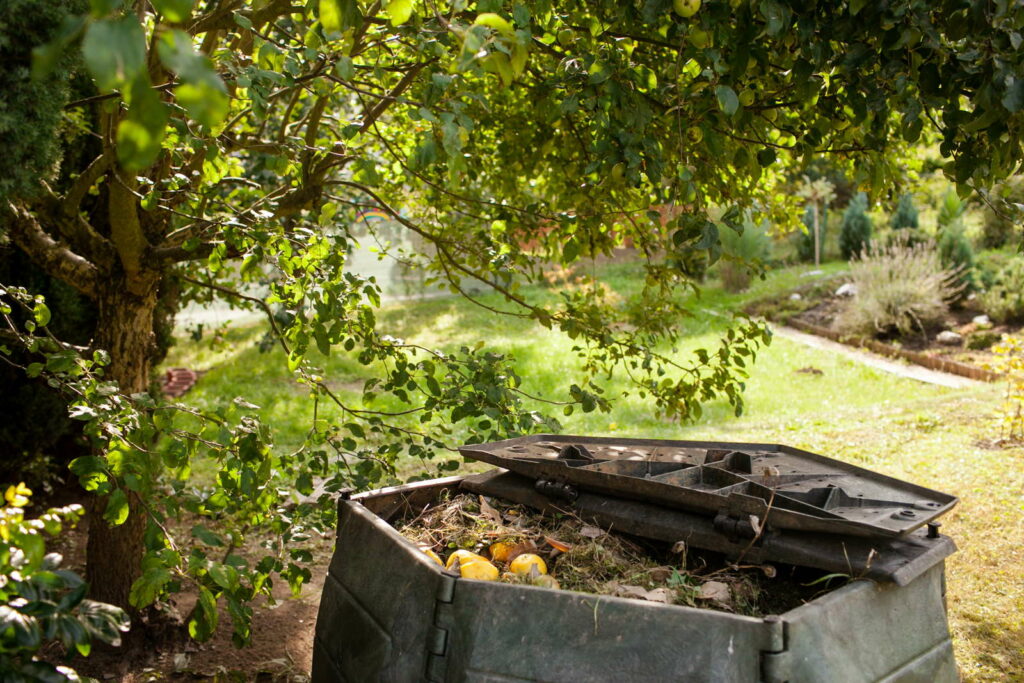 Composthoop in de tuin onder een fruitboom