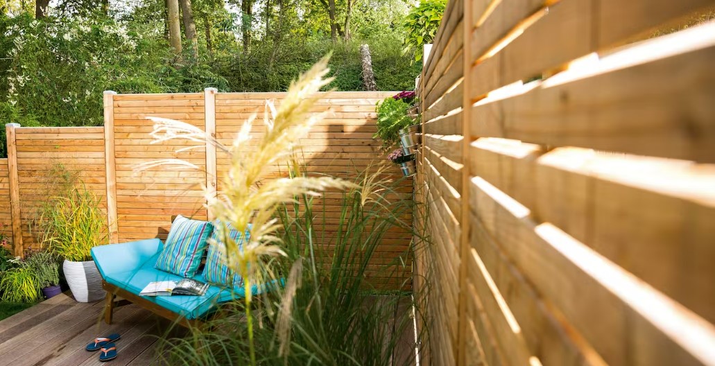 houten privacyscherm op een terras met tuinmeubelen
