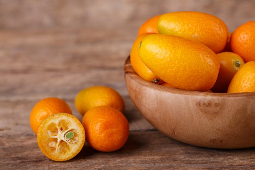 Gesneden kumquat naast een kom kumquats